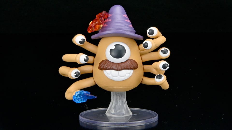 A Potato Head Beholder Miniature on a black background