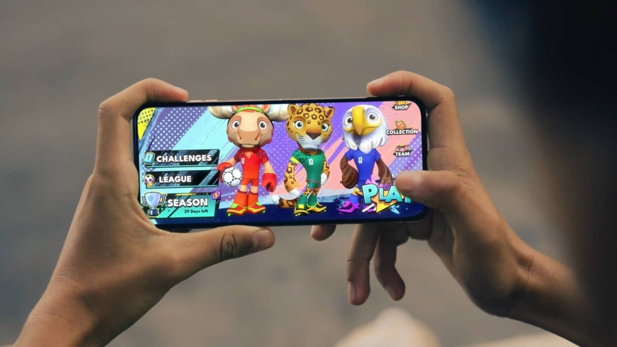 A player holding a phone that shows a FIFA Heroes menu