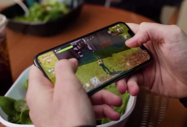 Someone playing Fortnite on iOS via their iPhone