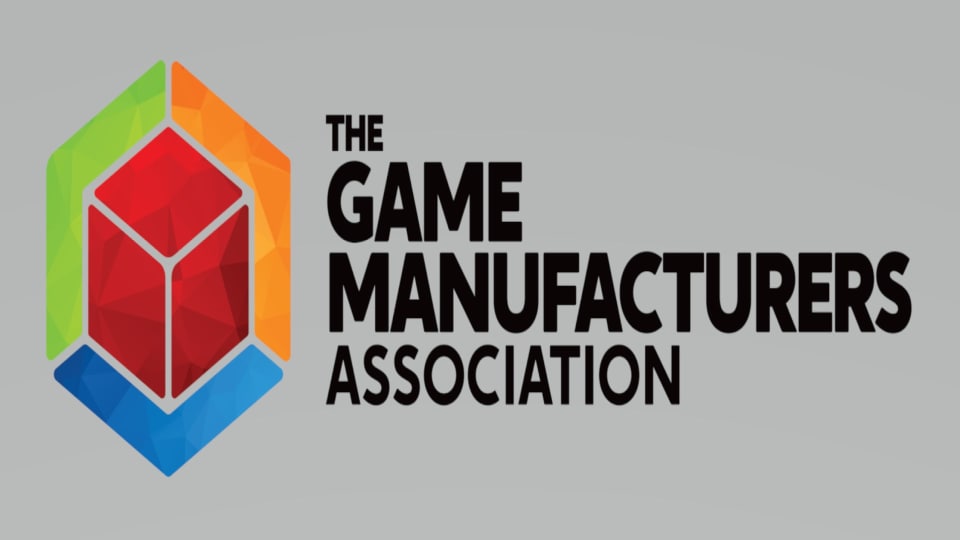 The logo for the Game Manufacters Association on a grey background.