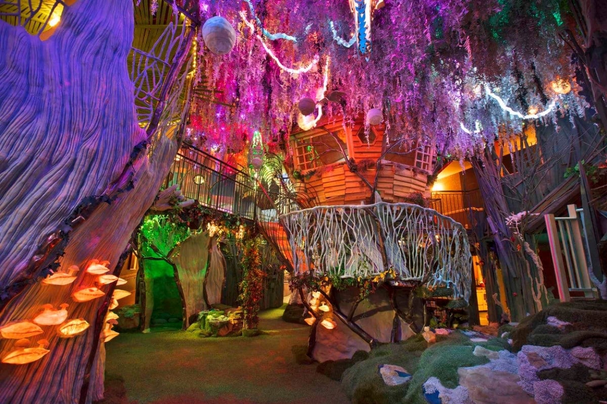 A screenshot of an exhibit room with multicolored treehouses and tree branches.
