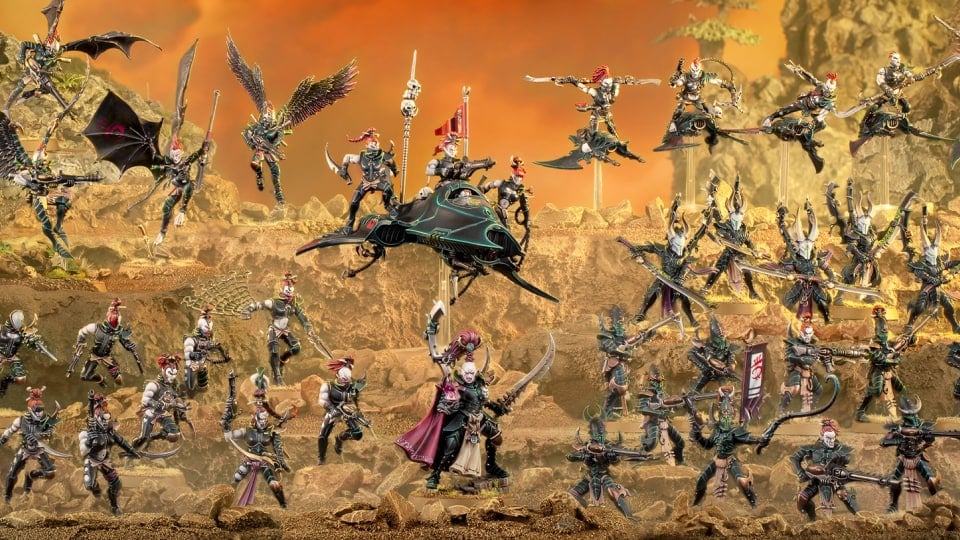Three rows of drukhari miniatures on a layered sandy mound.